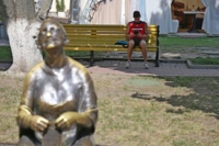 Мужчина отдыхает в тени рядом с театром имени М. С. Щепкина